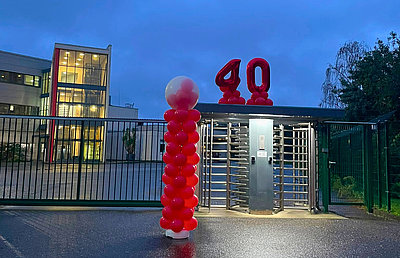 Zum Standortjubiläum ist das Tor mit roten Ballons geschmückt.
